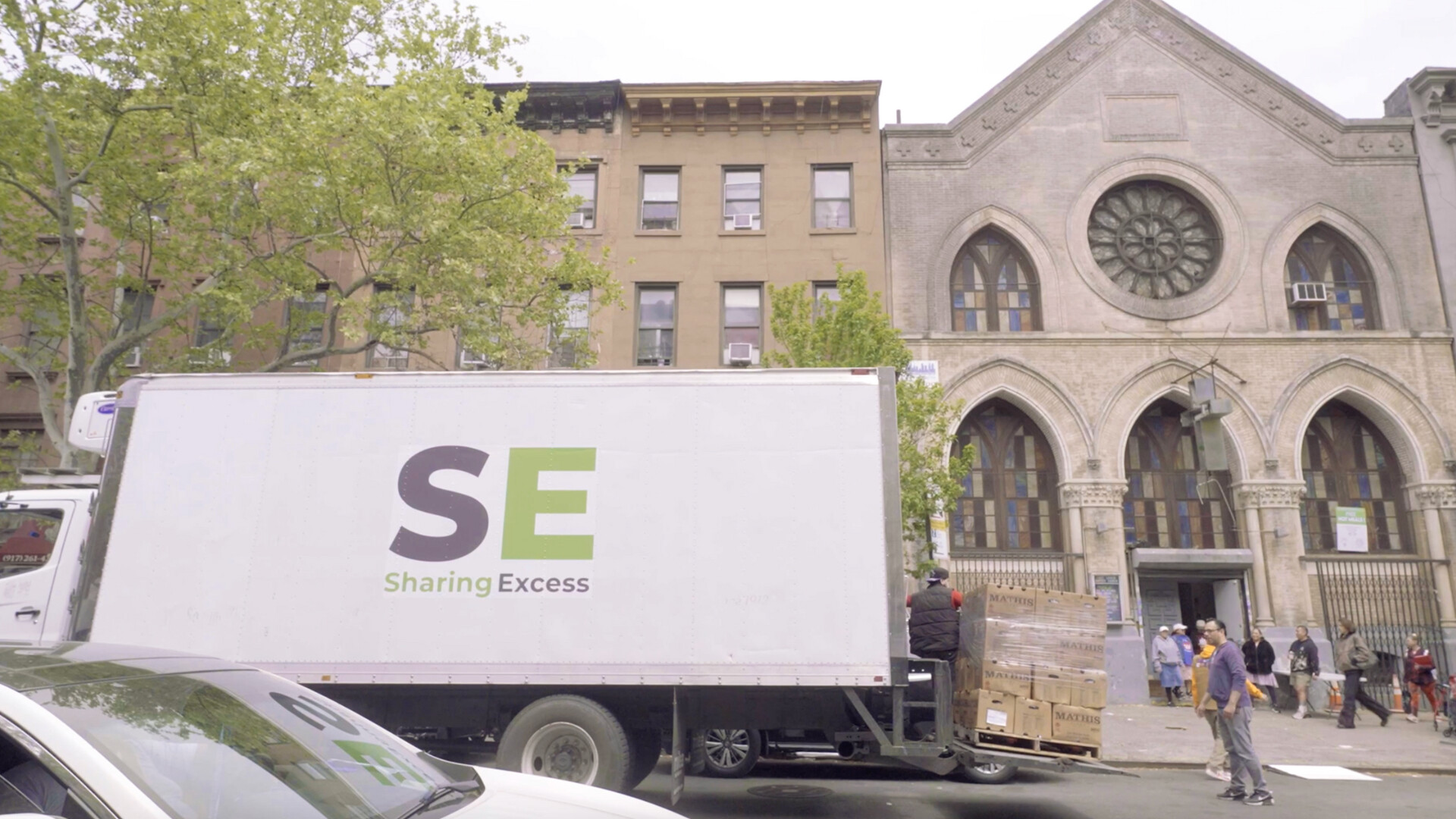 Sharing Excess truck delivering pallets of food to a church distribution site